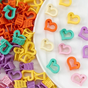 Détail macro de barrettes à cheveux en forme de cœur macaron sur une assiette blanche