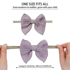 Détail d'un bandeau bébé extensible avec nœud en lin violet montrant sa grande élasticité