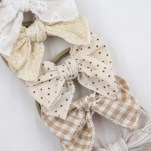 Detailed close-up of 5 baby bow headbands featuring lace embroidery and floral cotton fabric