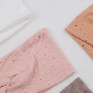 Detail of cross-knot hollow knit headbands in white, pink, orange, and grey colors