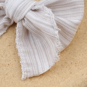 Detailed macro view of the embroidered linen bow hairband with raw edge vintage texture