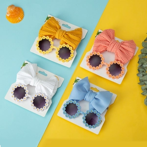 Detail of baby flower sunglasses and matching bow headbands in yellow, pink and blue