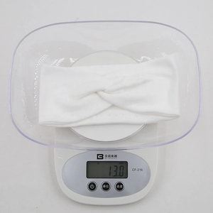 Detail shot of lightweight off-white yoga headband on scale weighing only 13 grams