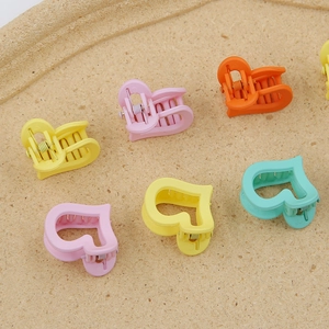 Détail de mini pinces à cheveux en forme de cœur mat coloré pour enfants avec design évidé
