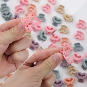 Vista dettagliata delle mini mollette a cuore opaco in vari colori macaron