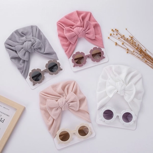 Détail de chapeaux en maille gaufrée pour bébés et lunettes de soleil fleurs