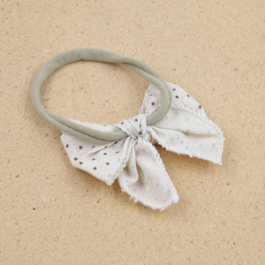 Elastic baby headband with a cream polka dot bow and morandi green nylon strap