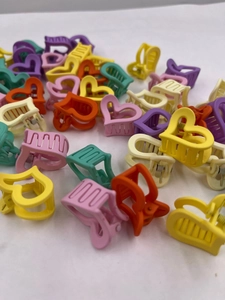 Vue détaillée de mini pinces à cheveux en forme de cœur mat aux couleurs variées
