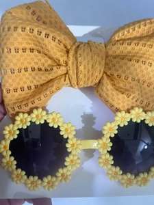 Flat lay of yellow daisy sunglasses and mesh bow headband set for toddlers and kids