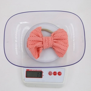 Detail showing an ultra-lightweight coral orange mesh bow headband weighing only 13g