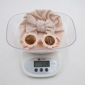 Mesure du poids de 54,9g pour l'ensemble turban bébé et lunettes de soleil