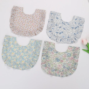 Lot de quatre bavoirs bébé en coton à motifs floraux et bords volantés sur blanc