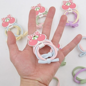 Détail d'élastiques à cheveux avec nœud sur carte, accessoires doux aux couleurs acidulées