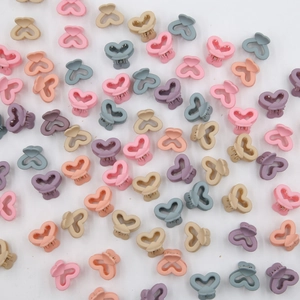 Dettaglio di mini mollette per capelli a forma di cuore opaco in colori pastello