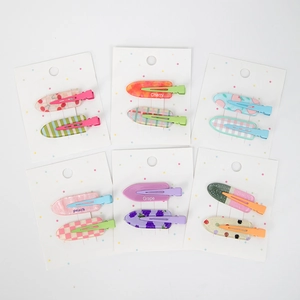 Détail de 12 barrettes à cheveux colorées en acétate avec motifs fruits et cœurs