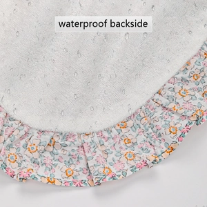 Détail du dos imperméable du bavoir en coton avec bordure volantée à fleurs roses