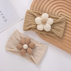 Détail de bandeaux souples pour bébé avec fleurs 3D et texture en maille torsadée