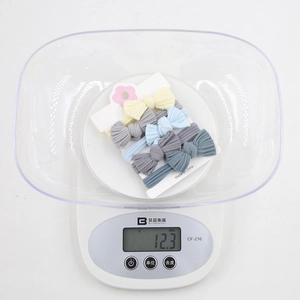 Detailed weight display of 5-piece seamless bow hair ties on a digital scale