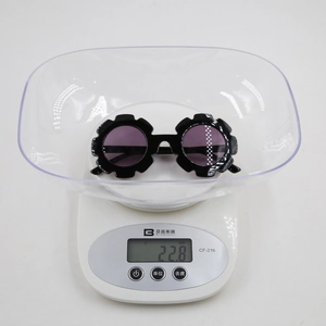 Détail montrant des lunettes fleurs enfant de 22,8g sur une balance