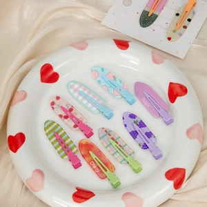 Détail de barrettes à cheveux en forme de cœur coloré avec motifs de fruits
