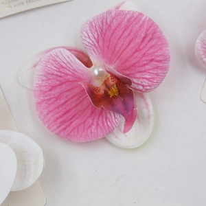 Macro shot of pink orchid flower hair clip with realistic petal texture and center pearl