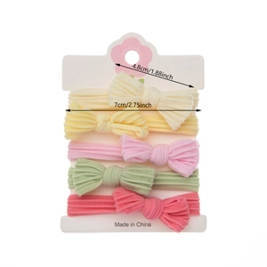 Set of four bow baby headbands in beige pink green and rose red on white packaging card