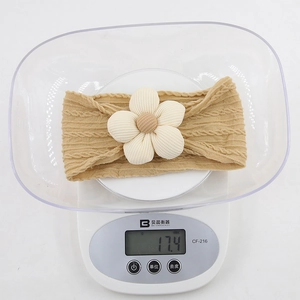 Détail d'un bandeau en maille pour bébé kaki avec fleur, affichant un poids précis de 17,4 g