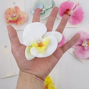 Detailed view of artificial orchid hair clips with pearls in various pastel colors