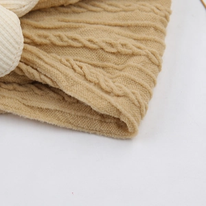 Gros plan du bandeau tricoté pour bébé montrant les mailles torsadées et texture