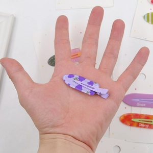 Vue détaillée d'une mini pince à cheveux violette avec un motif de raisin mignon