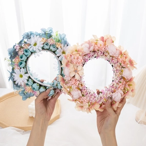 Detailed view of floral Mickey-ear headbands in soft pink and blue artificial silk flowers