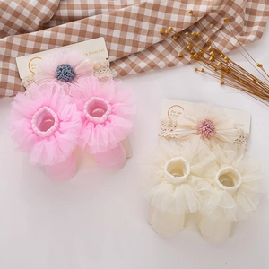 Detail of baby headband and sock set with lace floral design for ages 0-2 years