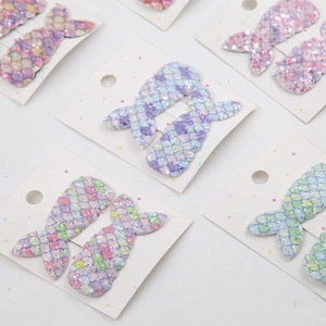 Detail of sequined mermaid tail hair clips in pastel gradient colors on display cards