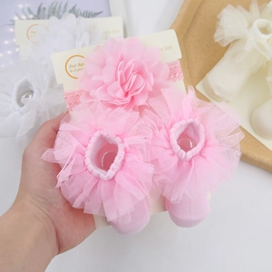 Close-up of pink chiffon flower headband and lace socks set for infants aged 0-2 years