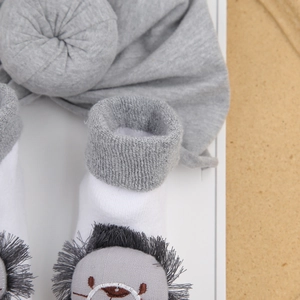 Detailed view of baby cotton set with lion head socks and matching gray headband