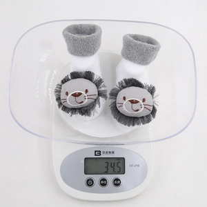 Detail shot of baby floor socks showing actual weight of 34.5g on a digital scale