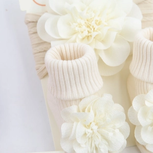 Detailed macro view of infant chiffon flower headband and ribbed knit cotton socks set
