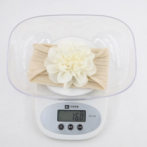 Close-up of lightweight 16g beige baby nylon headband with large floral detail