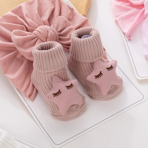 Vue détaillée de chaussettes en tricot pour bébé roses avec nœud papillon assorti