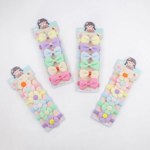 Détail d'élastiques à cheveux colorés avec fleurs et nœuds sur cartes pour fillettes