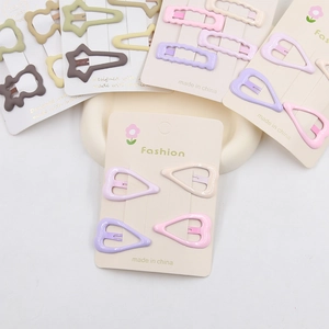 Macro detail of colorful star and heart metal hair clips in macaron tones on a display card