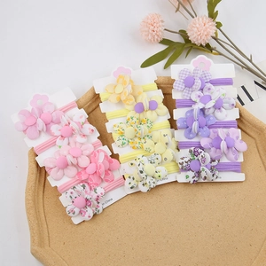 Vue détaillée des chouchous à fleurs en tissu coloré sur des cartes de présentation blanches