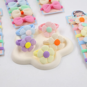Gros plan sur les chouchous fleurs élastiques et nœuds papillons aux couleurs macarons
