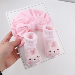 Coffret cadeau rose pour bébé avec un bandeau à gros nœud et des chaussettes lapin