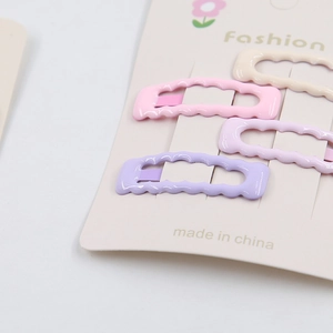 Detail of four-piece wavy hair clips set in pastel macaron colors on display card