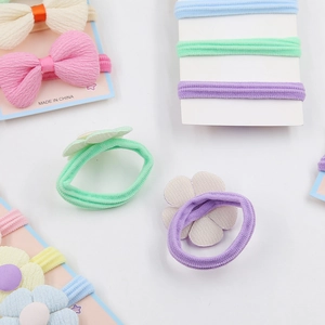 Détail d'élastiques cheveux pour enfants avec fleurs en tissu et nœuds colorés