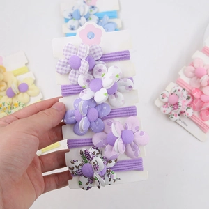 Détail d'élastiques à cheveux avec fleurs en tissu faites à la main pour petites filles