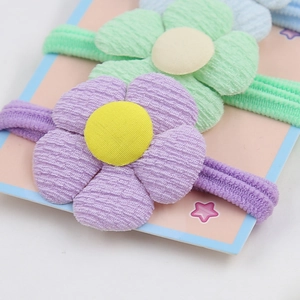 Détail d'élastiques à cheveux fleurs colorés en tissu côtelé pour enfants et filles
