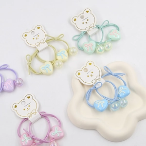 Detail of colorful macaque heart charms and beads on elastic hair ties for girls