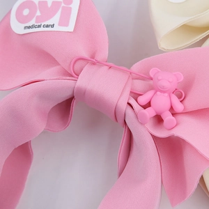 Nahaufnahme des rosa Stoff-Haarreifens mit 3D-Bärenanhänger und Sicherheitsnadel-Detail